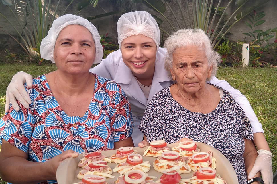 Funcionária e Residentes fazendo pizza