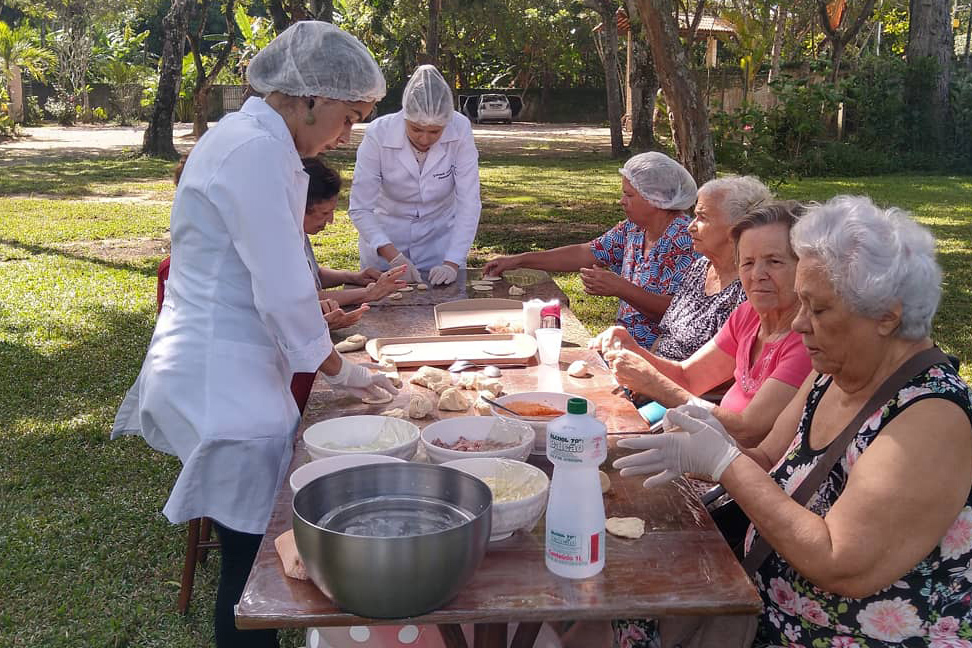 Funcionários e residentes fazendo pizza